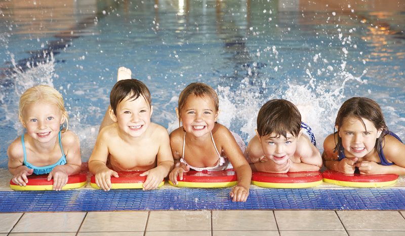 Young children splashing by pool